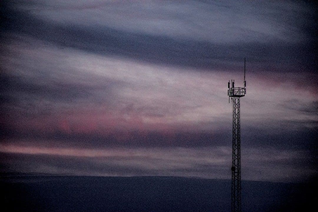 A radio tower reaches towards a moody sunset. — Photo Joaquín Cuesta Fuentes / Unsplash