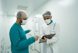 Two medical professionals are having a discussion. — Photo Mina Rad / Unsplash