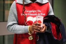 a woman in a red vest holding a cup — Photo Danielle-Claude Bélanger / Unsplash