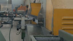 A high-speed industrial saw cuts through a metal piece, sending fine metal shavings into the air. The motion blur on the spinning blade emphasizes the power and precision of the cutting process. — Photo Cemrecan Yurtman / Unsplash
