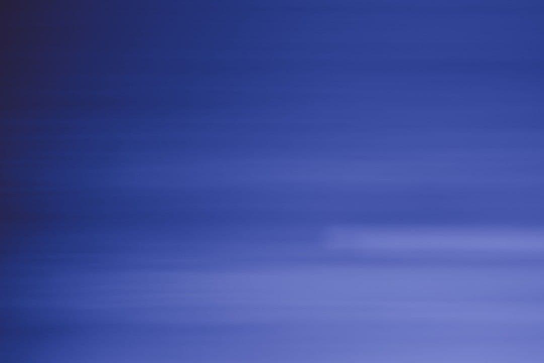 a blurry photo of a plane flying in the sky — Photo Yves Cedric Schulze / Unsplash