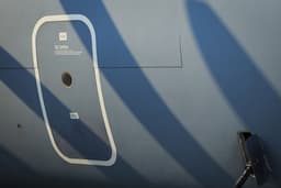Military transport aircraft door with propeller shadows — Photo AGUNG SUKSMANTO / Unsplash