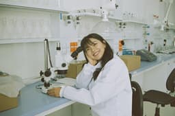 woman in white laboratory gown holding black microphone — Photo Diane Serik / Unsplash