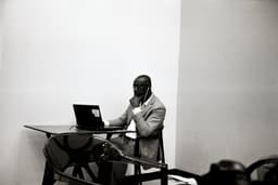 a man sitting at a table using a laptop computer — Photo ONUR KURT / Unsplash