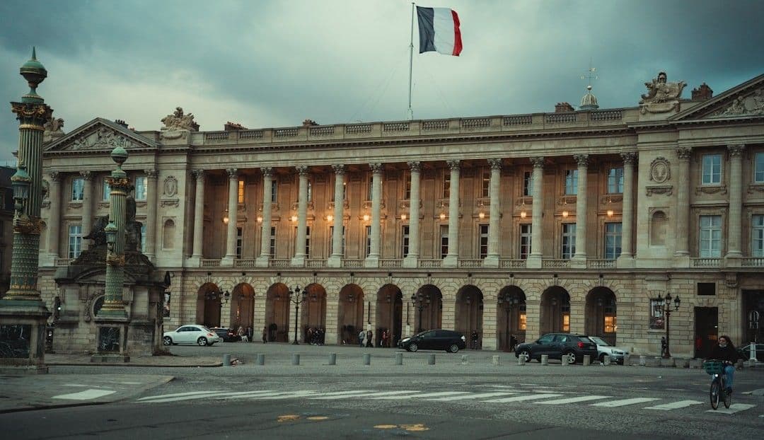 a large building with a flag on top of it — Photo Anna Hunko / Unsplash