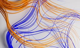 a bunch of orange and blue wires on a white surface — Photo Sumaid pal Singh Bakshi / Unsplash