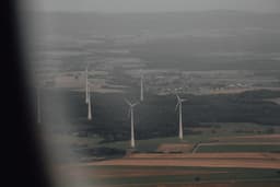 a view of a wind farm from a plane — Photo Thomas De Giorgio / Unsplash
